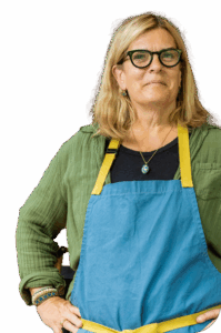 A chef from one of Cambridge's top restaurants poses confidently in a blue and yellow apron.